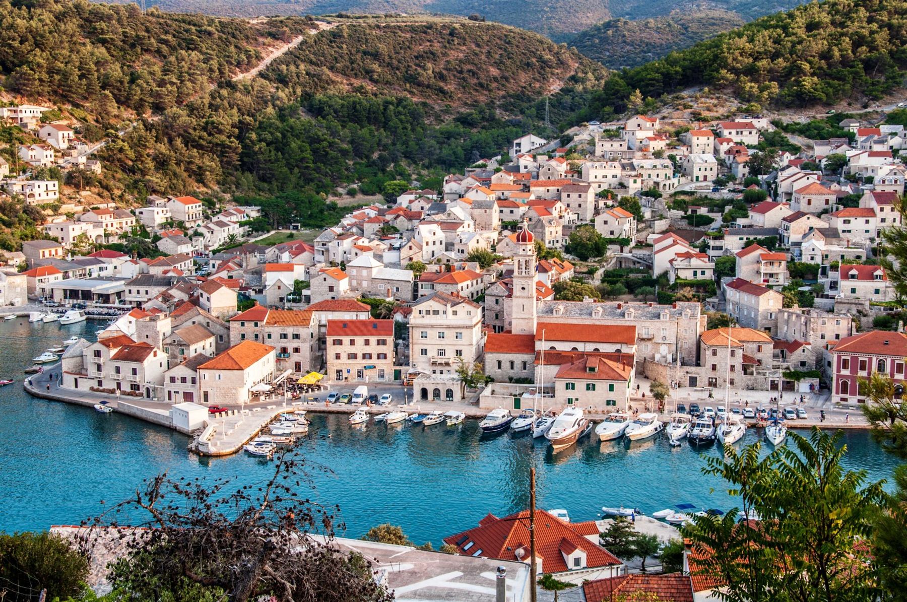 Zračni pogled na luku i marinu Pučišća u zlatnom svjetlu zalaska sunca